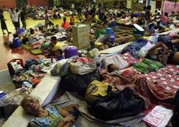 Multitud de filipinos se acuestan en el suelo de un gimnasio. / Efe | Atlas