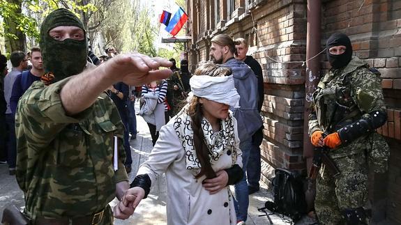 Separatistas prorrusos llevan a la periodista Irma Krat con los ojos vendados. 