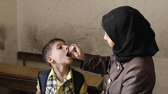 Una activista administra la vacuna contra la polio a un niño en Aleppo. 