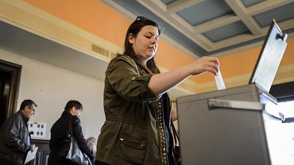 Una mujer vota en Bulle (Suiza). 