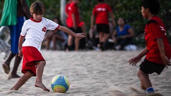 Unos niños juegan al fútbol en la playa de Ipanema (Brasil).