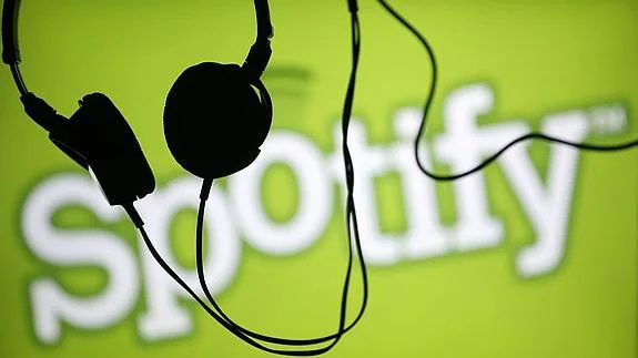 Auriculares frente al logotipo de Spotify , servicio de streaming online de música