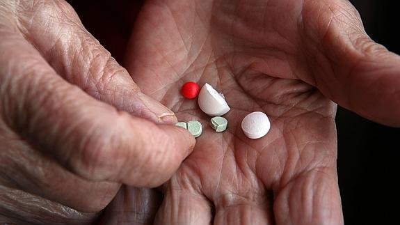 Un anciano se dispone a tomarse sus medicamentos diarios. 