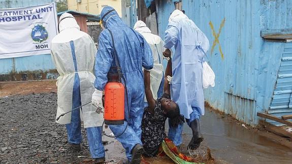 Enfermeros cargan a una paciente sospechosa de poseer el virus del Ébola.