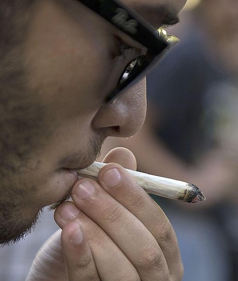 Un joven fumando un cigarrillo de marihuana. 