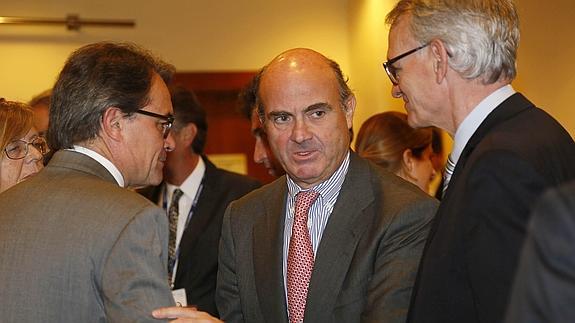 El ministro de Economía, Luis de Guindos (c), conversa con el presidente de la Generalitat, Artur Mas (i), y el presidente del Círculo Economía, Anton Costas (d).