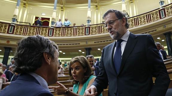 Mariano Rajoy conversa con el portavoz parlamentario del PP, Rafael Hernando (i).