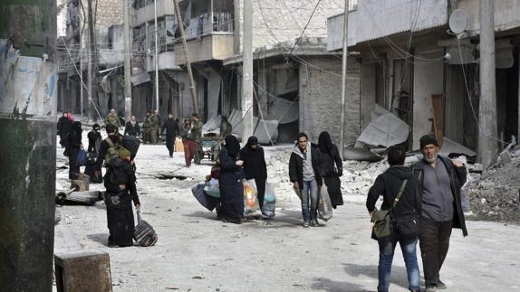 Varias personas evacuan un barrio en Alepo (Siria).