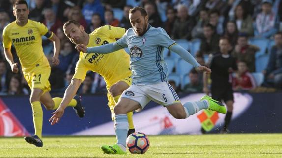 El centrocampista chileno del Celta de Vigo, Marcelo Díaz (d), se dispone a golpear el balón ante el delantero del Villarreal, Roberto Soldado, 