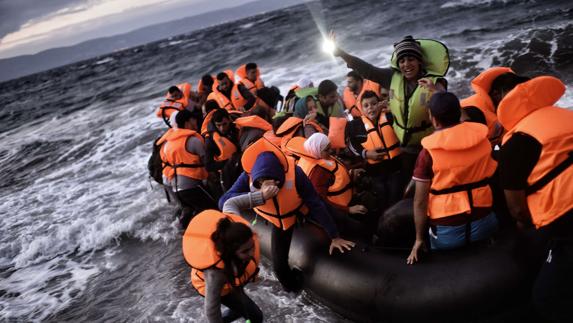 Refugiados sirios arriban en una barca neumática a las costas de la isla griega de Lesbos.
