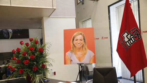 Libro de condolencias, un ramo de flores y un retrato de Carme Chacón.