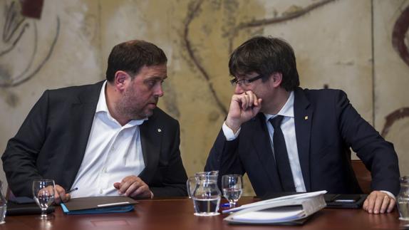 El presidente de la Generalitat, Carles Puigdemont con el vicepresidente del Govern, Oriol Junqueras.