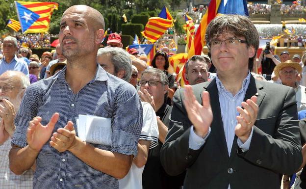 Guardiola (i) y Puigdemont aplauden. 