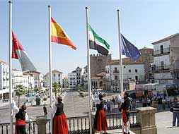 Izado de banderas en un acto institucional celebrado en la Plaza Mayor de Cáceres./ HOY