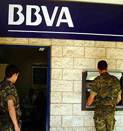 Dos militares hacen uso del cajero  intalado en la única oficina bancaria que hay en el cuartel. / HOY