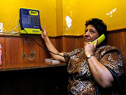 Una mujer telefonea a su familia en el Locutorio Público Extremeño. / JOSÉ VICENTE ARNELAS