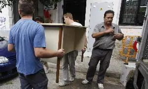 Conserje de un colegio de Mérida ayudando al traslado de mobiliario. / HOY