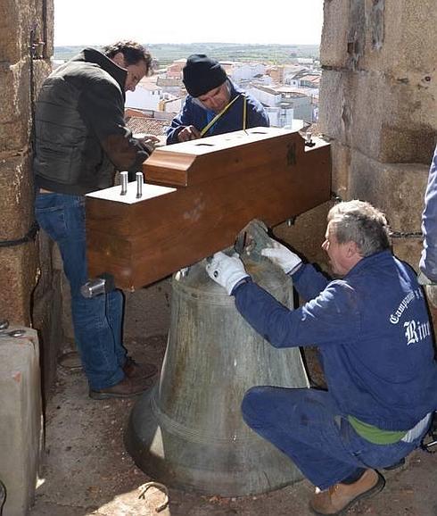 Los trabajadores de la empresa colocando los yugos a las campanas de la torre de Montehermoso