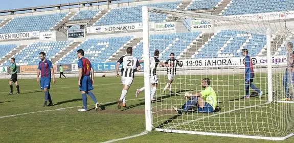 Saavedra, meta del Extremadura, observa sentado junto a la línea de gol la celebración de uno de los tantos blanquinegros. 
