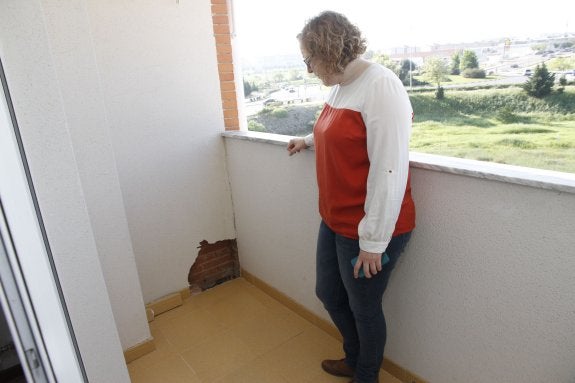 Laura Martín, cuya vivienda ha sido precintada, muestra una de las catas que han hecho los técnicos en su terraza. :: armando méndez