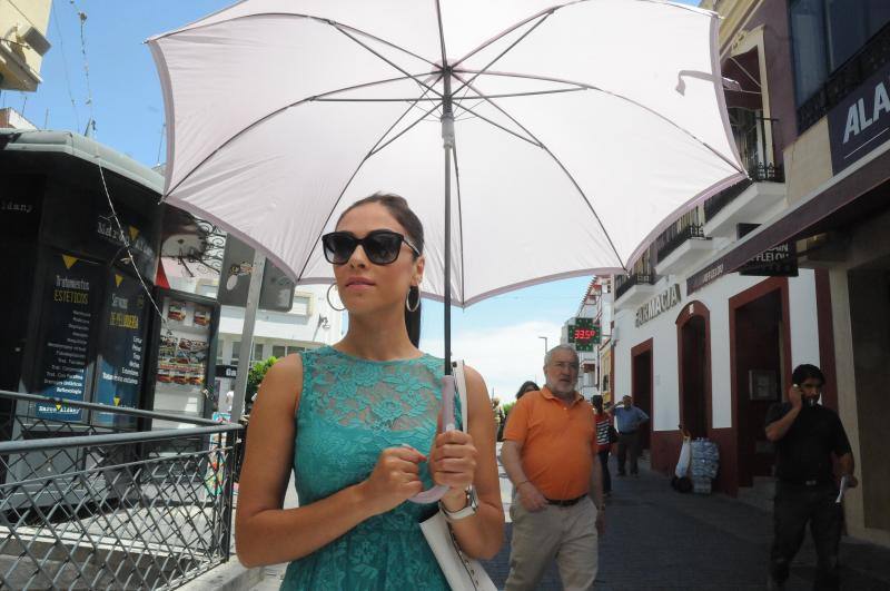 Una joven camina protegida del sol con un paragüas por la calle Santa Eulalia de Mérida .