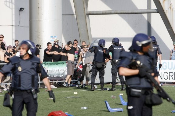 Los antidisturbios junto a aficionados del Mérida que se quejan de su actuación. :: Pardo