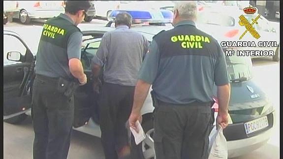 Momento en el que la Guardia Civil traslada a uno de los detenidos en la operación llevada a cabo contra bandas organizadas dedicadas al roo en zonas rurales.