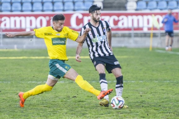 Mikel Uriarte controla el balón ante la presión de Atón, jugador del Olivenza. :: josé vicente arnelas