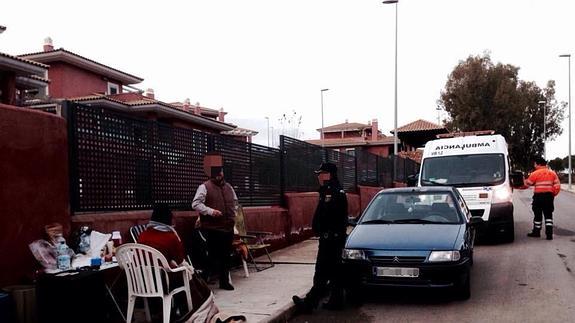 Una agente conversando con algunas de las personas acampadas frente a la casa de Monago