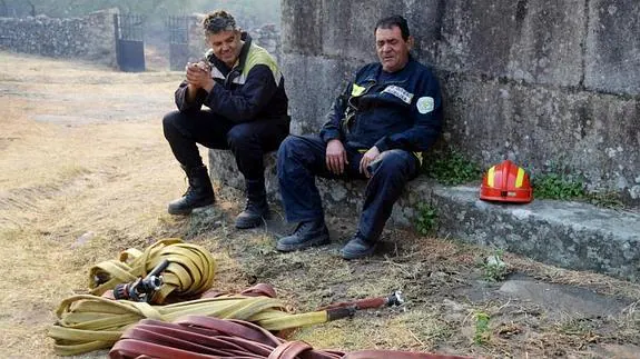 Bomberos que han trabajado en las labores de extinción de las llamas que esta madrugada han rodeado Hoyos::EFE