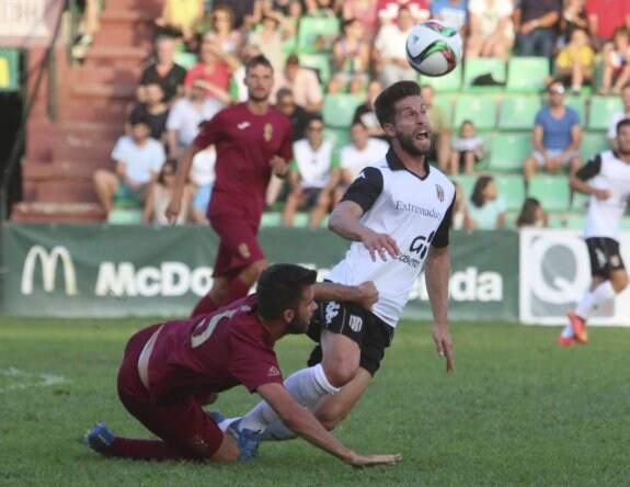 El delantero del Mérida, Pedro Conde, intenta llevarse el balón ante el murciano Manu Torres. :: J. M. ROMERO