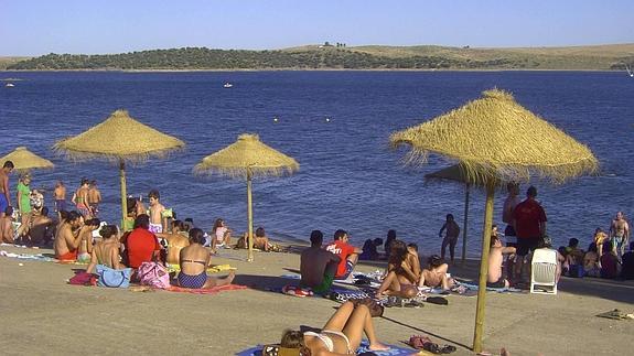 Panorámica de la playa de Orellana la Vieja, que también cuenta con sombrillas para los bañistas.