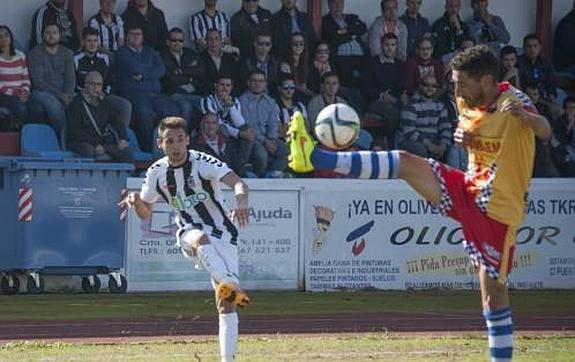 Álex González centra ante Santi Polo en el partido Badajoz-Arroyo disputado en Olivenza. :: pakopí