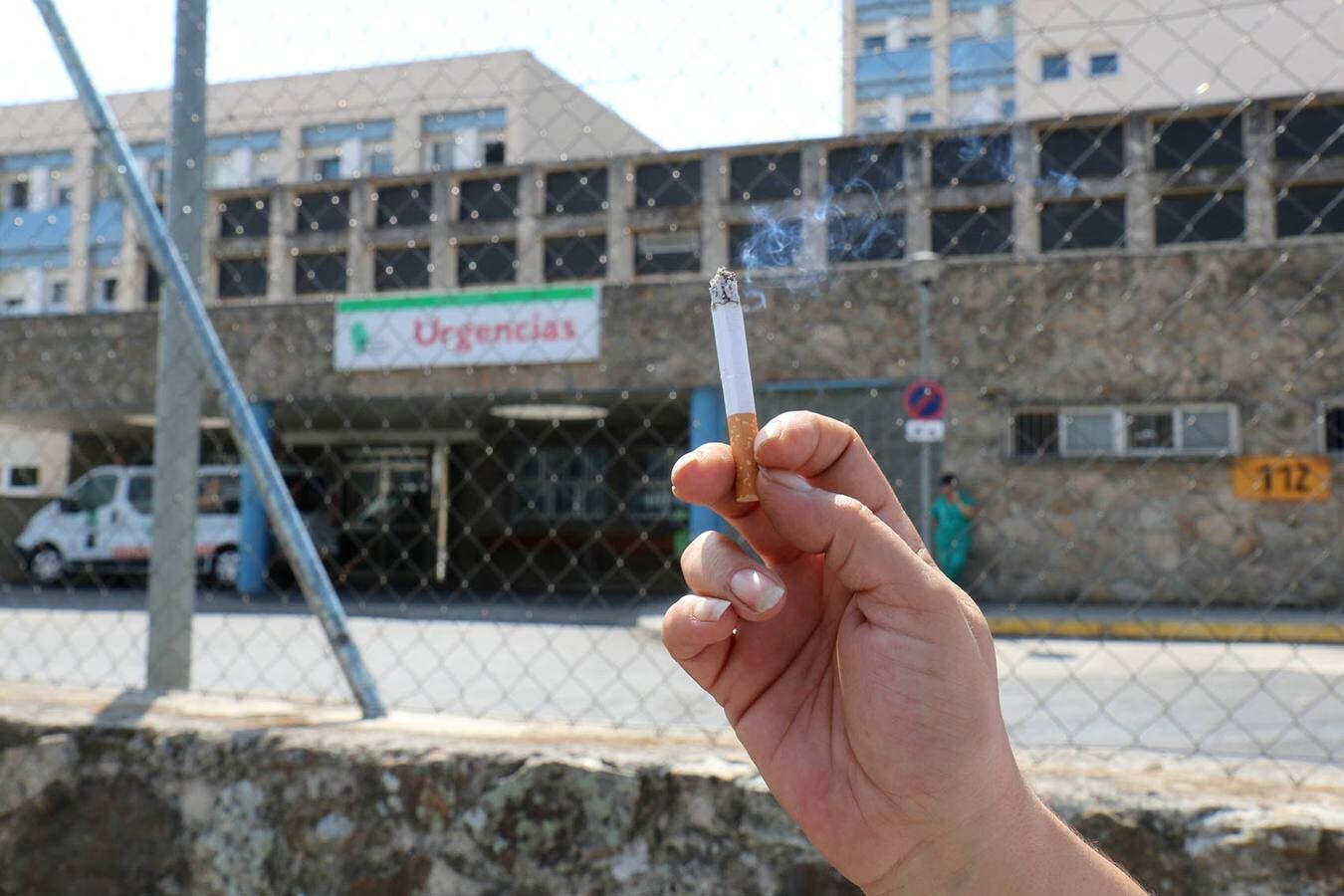 Una mujer fuma un cigarrillo junto a la verja que limita el recinto del Hospital Virgen del Puerto de Plasencia:: ANDY SOLÉ