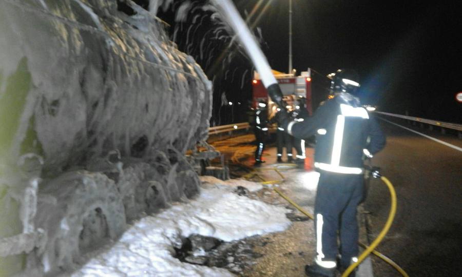 Los bomberos apagan el vehículo incendiado.::