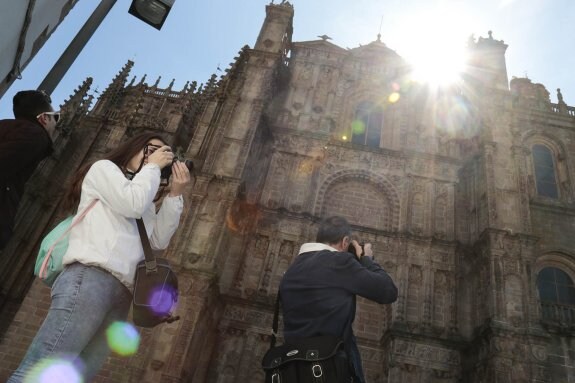 Turistas sacando fotos frente a la catedral nueva el pasado Jueves Santo. :: andy solé