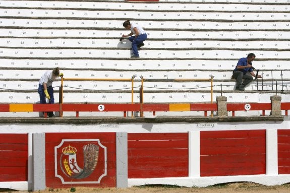 Operarios adecentando la Plaza de Toros de Cáceres para la feria de San Fernando de 2012. :: HOY