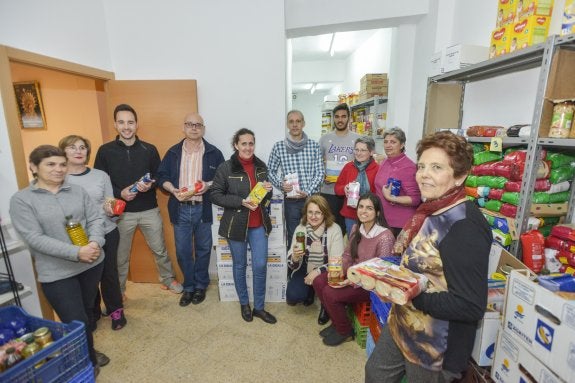 Los voluntarios preparan los lotes que entregan a unas 80 familias necesitadas del barrio. :: j. v. arnelas