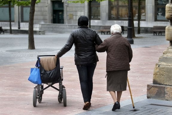 Imagen de archivo de una cuidadora con una mayor dependiente durante un paseo. :: hoy