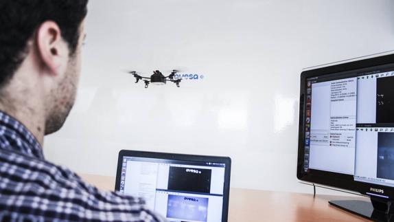 Un trabajador de Ayesa junto a un dron en vuelo.