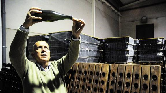 El bodeguero Marcelino Díaz, de Almendralejo, con una botella de cava en sus instalaciones. :: 