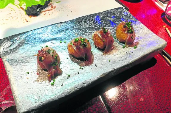 Muñoz, en la cocina de su restaurante de Londres. En pequeño, las croquetas Pedroche. :: R. C.