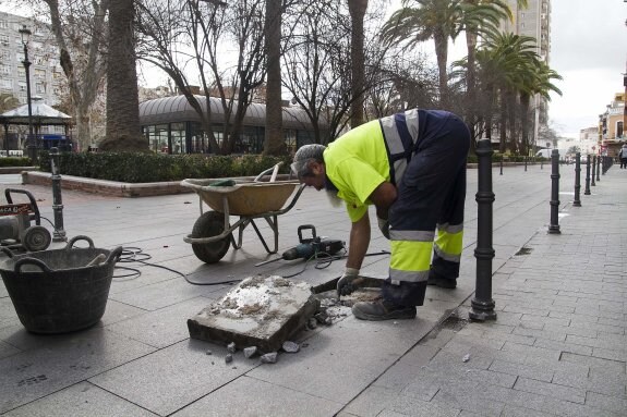 Un operario del Servicio de Vías y Obras sustituye una de las losas que se movían. :: teresa benítez