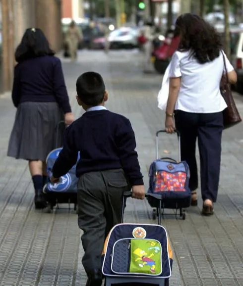 Escolares con sus mochilas en dirección al colegio