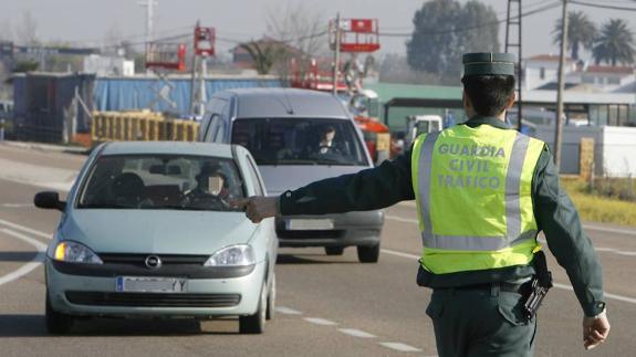 Un agente de la Guardia Civil de Tráfico para un coche durante un control sobre el uso del cinturón de seguridad.