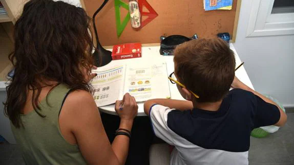 Una madre ayuda a su hijo con los deberes que tiene para hacer en casa.