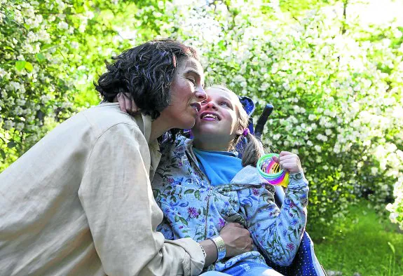 Elena Álvarez, en un parque de Madrid con la tercera de sus cuatro hijos, Lucía, que nació con síndrome de Angelman, una enfermedad genética rara. :: elvira megías