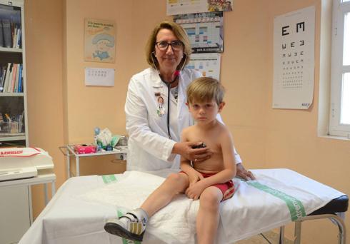 Mercedes Reymundo, con un niño en la consulta que hoy deja tras 25 años en un centro de salud. :: c. m.