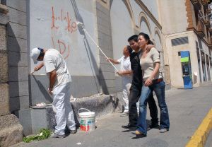 SAN JUAN DE RIBERA. Dos operarios quitan las pintadas. / C.M.