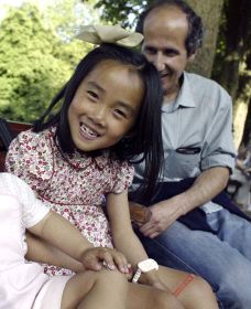 Un niña china sonríe junto a su padre adoptivo. / HOY